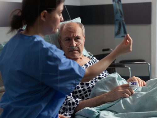 Medical nurse analyzing senior patient x-ray in hospital room